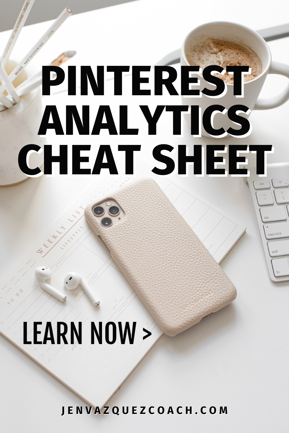 Desk with beige cell phone holder, keyboard, ear budgs and writing saying Pinterest Analytics Cheat Sheet