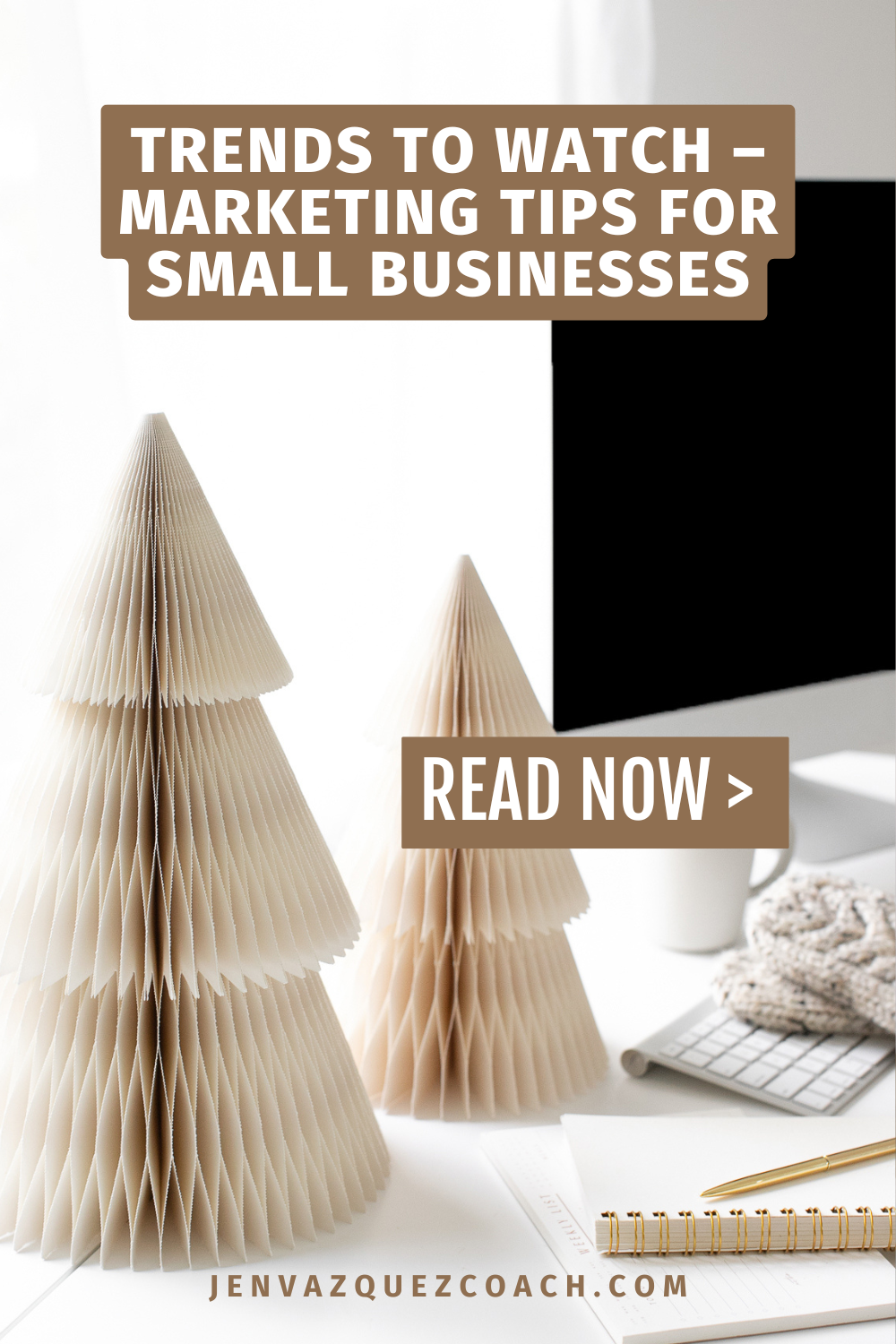 Image features paper Christmas trees on a desk with a computer, notebook, and coffee cup. Text overlay reads 'Trends to Watch – Marketing Tips for Small Businesses. Read Now.' A cozy, professional atmosphere. by Jen Vazquez Media